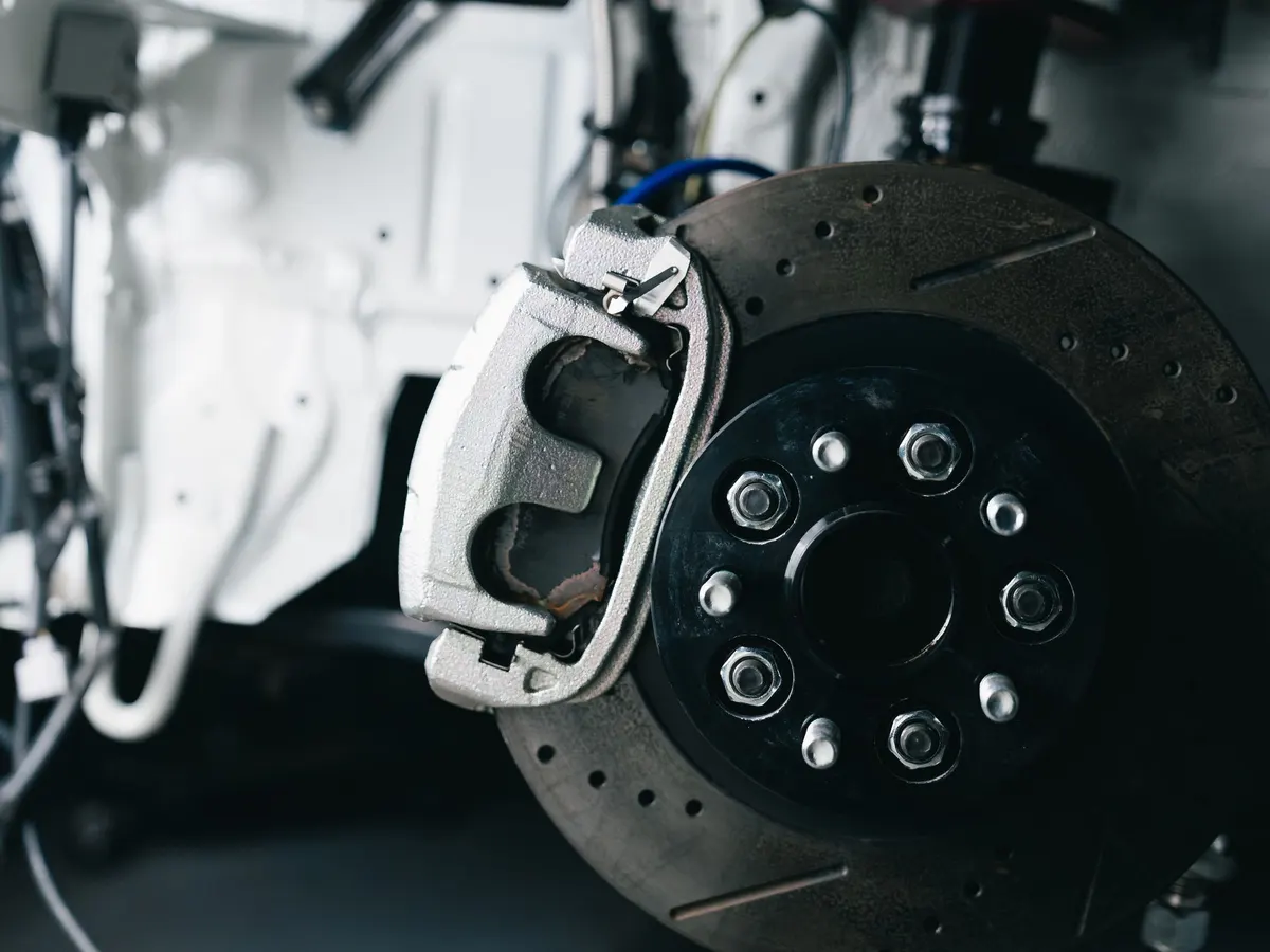 Close-up of a brake disc and caliper behind a wheel