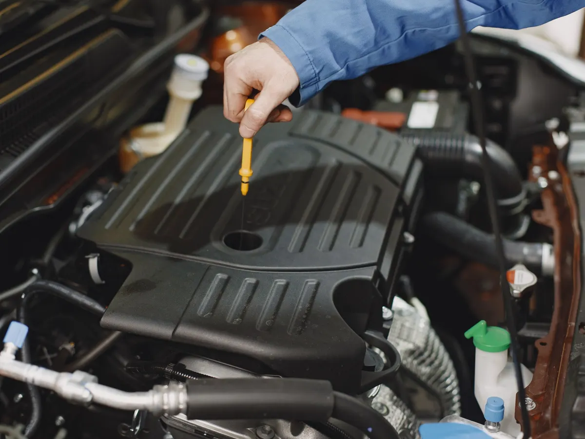 Fresh motor oil being poured into an engine during an oil change